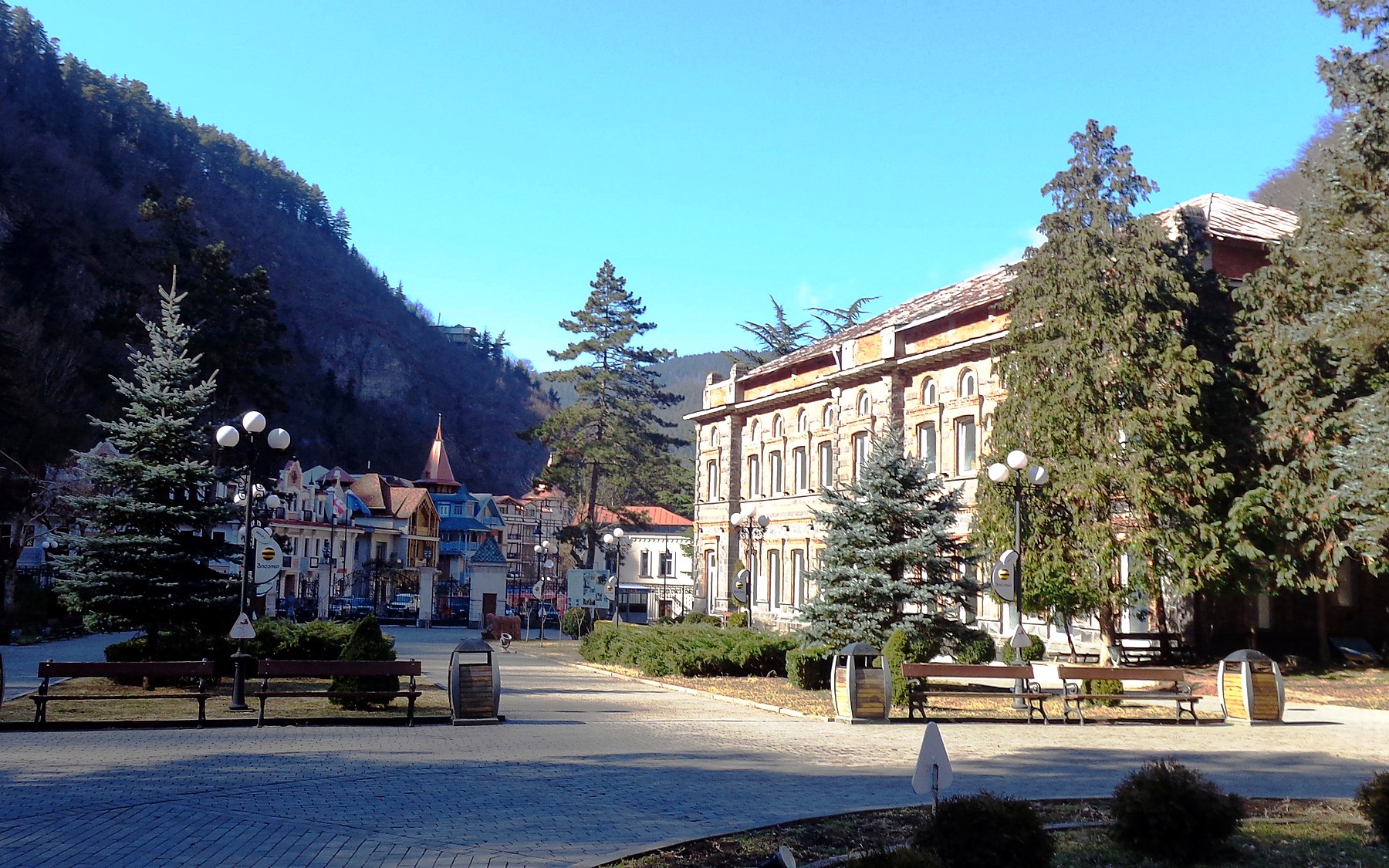 Turquoise pavilion in Borjomi Central Park among green trees