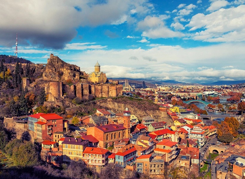 Old Tbilisi rooftops and Narikala Fortress on a bright day
