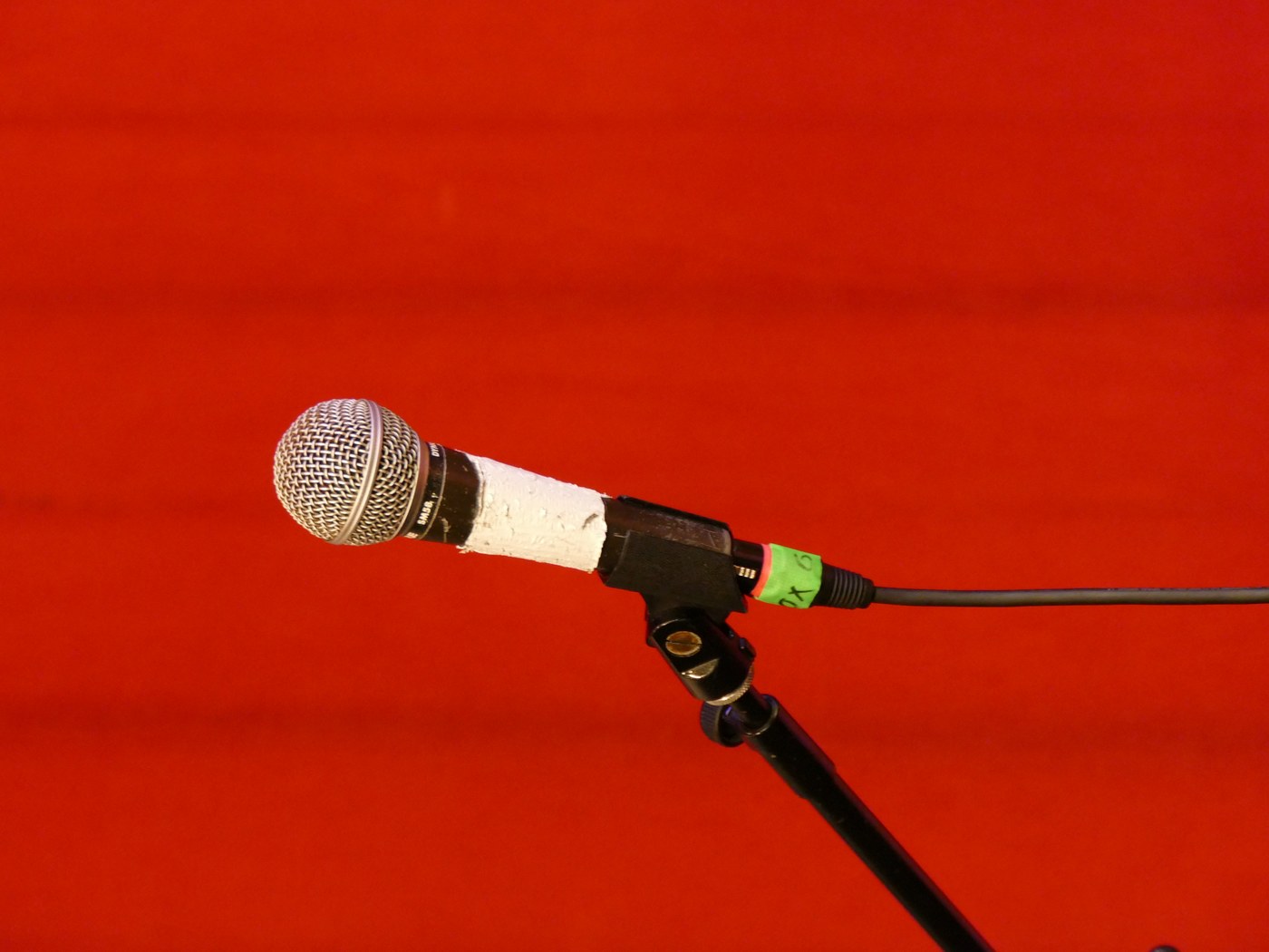 Microphone on a stand against a deep red backdrop