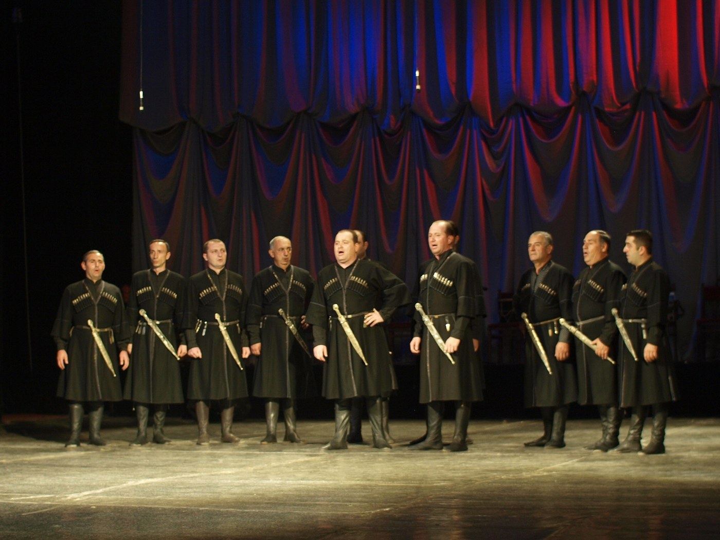 Georgian folk singers in black chokhas performing on stage in Batumi