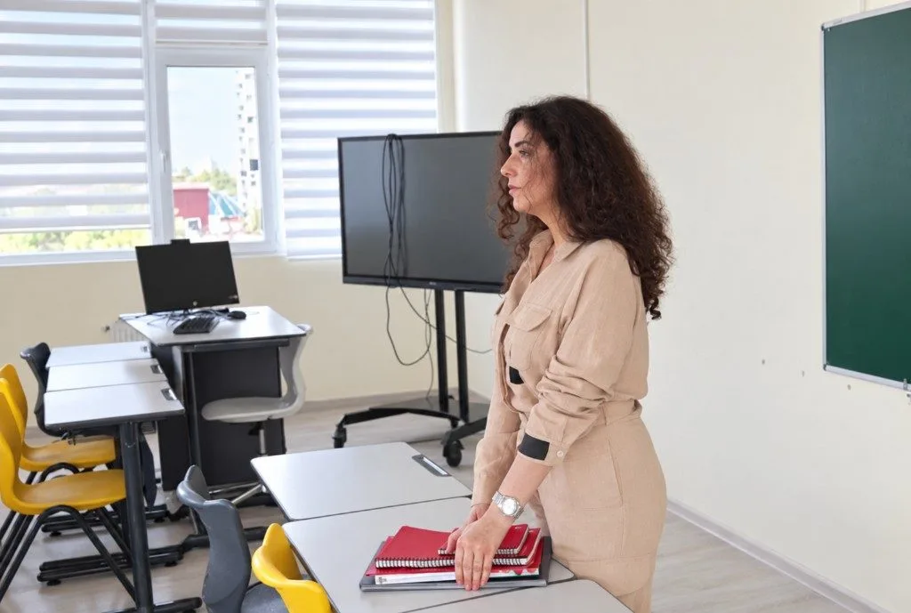 A teacher at a desk in the classroom